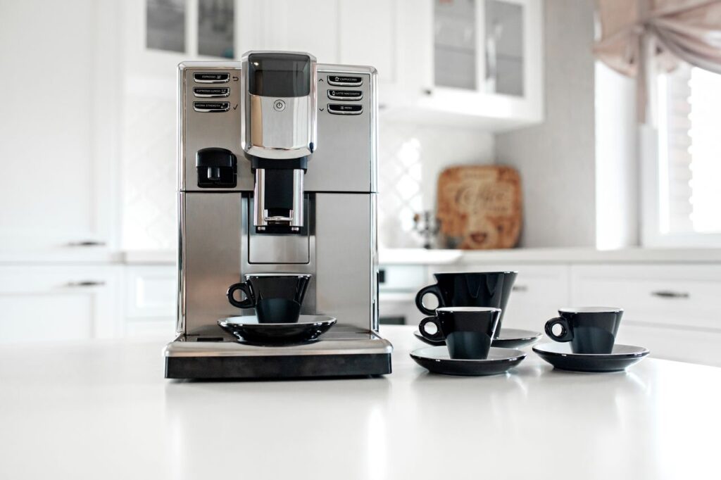 Machine à café silencieuse avec tasses à expresso sur la table de la cuisine.